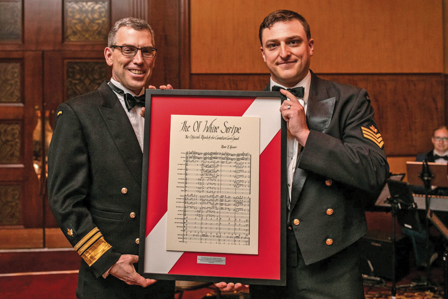 Canadian Coast Guard Commissioner Jeffrey Hutchinson, left, and PO2 Matt Reiner of the Stadacona Band, show the framed sheet music for The Ol’ White Stripe, the new official Coast Guard March. Photo by Melanie Rebane Photography
