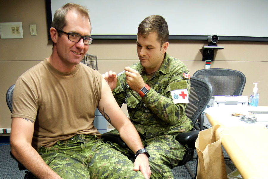 Corporal Mark-Andre Bertrand-Bigras, a Medical Technician with Canadian Forces Health Services Centre (Pacific), administers a flu shot to his Commanding Officer, Lieutenant Colonel Gordon Peckham, during a flu shot clinic in Dockyard. Photo by Peter Mallett, Lookout