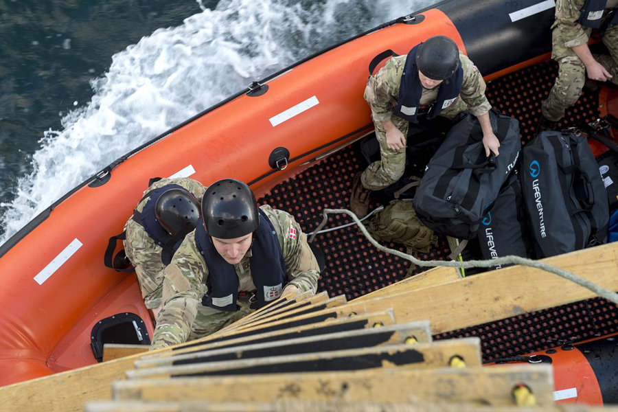 Members of the Royal Danish Navy’s Boarding Party climb-up HMCS Charlottetown as part of a cross-nation training exercise during Operation Reassurance on Sept. 18.  Photo by Corporal J.W.S. Houck, Formation Imaging Services