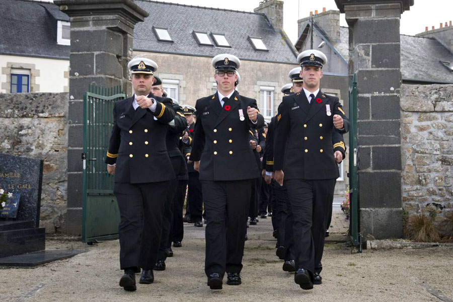 The ship’s company of HMCS Montréal marches through the gates of Plouescat Cemetery. Photo by LS Dan Bard, Formation Imaging Services