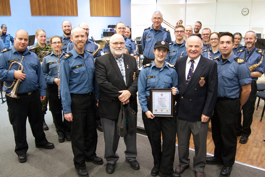 Naden Band composer and saxophonist Petty Officer Second Class Robyn Jutras (centre) is joined by fellow band members as she is presented an honorary membership in the Submariners Association of Canada (SAOC) by SAOC Canada West President, Lloyd Barnes (right) and past president Paul Hansen. The two former RCN submariners dropped by the band headquarters Nov. 21 to show their appreciation to PO2 Jutras for composing an official SAOC march entitled The Dolphin March. Photo by Peter Mallett, Lookout Newspaper