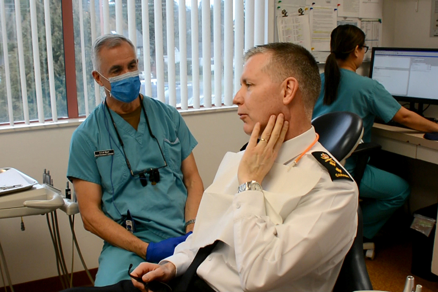 Lieutenant-Colonel Bob Hart, Commander 1 Dental Detachment Unit Esquimalt, talks teeth with Rear Admiral Art McDonald, Commander Maritime Forces Pacific, as Jinky Apayo, a Certified Dental Assistant, prepares for the Admiral’s checkup. The checkup was part of RAdm McDonald’s work with the dental unit after it secured his services in the “You’re the Boss” auction in support of the National Defence Workplace Charitable Campaign. Photo credit: Rodney Venis, Base Public Affairs