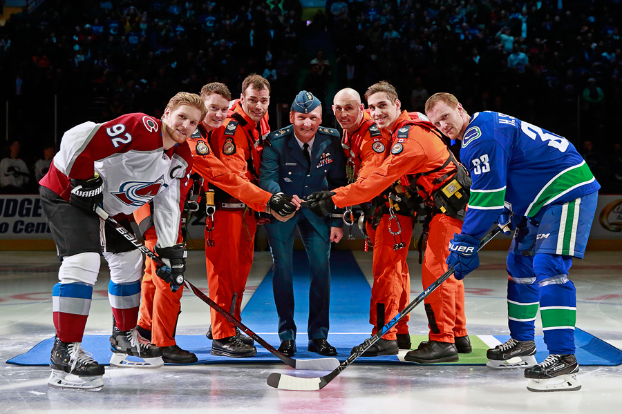 Team Captain of the Colorado Avalanche Gabriel Landeskog (left) and Vancouver Canucks captain Henrik Sedin are joined by Brigadier General Dave Cochrane (centre) of the Royal Canadian Air Force, and members of 442 Squadron, for the ceremonial opening faceoff during Military Appreciation Night at Rogers Arena, Jan. 30. Photo by Jeff Vinnick, NHLI