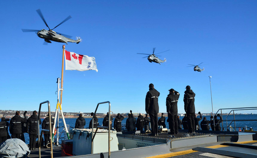 Royal Canadian Navy personnel wave and salute as 423 Maritime Helicopter Squadron conducts its final flight with CH-124 Sea King helicopters over Halifax Harbour Jan. 26. Photo by DND