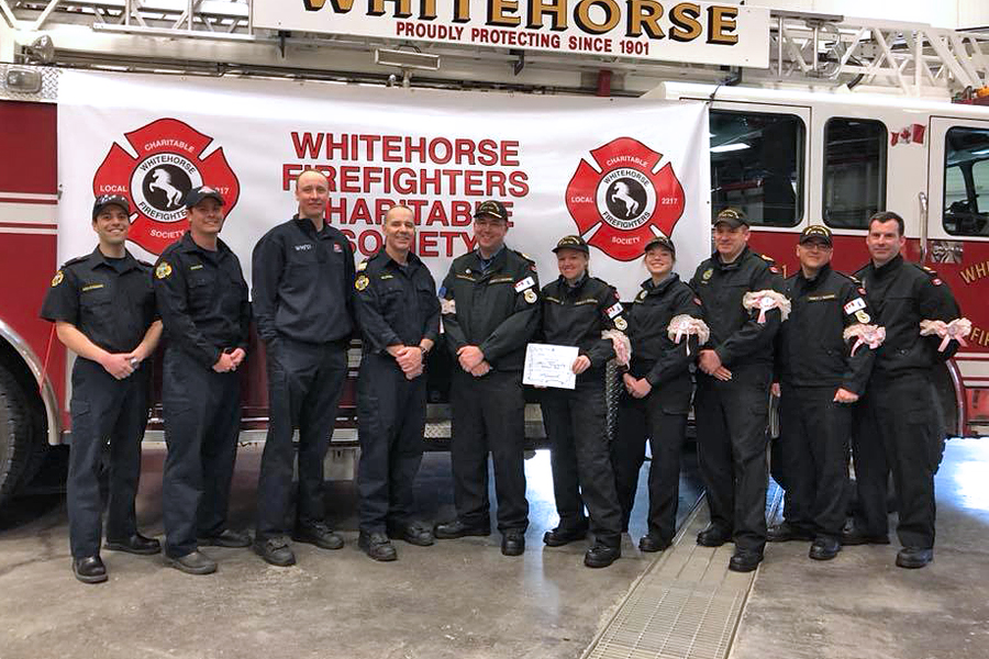 The team representing HMCS Whitehorse donates their $250 prize to the Whitehorse Firefighters Charitable Society.
