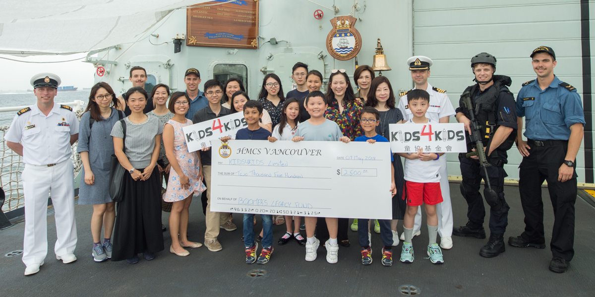 HMCS Vancouver Commanding Officer, Commander Christopher Nucci, Coxswain Chief Petty Officer First Class Steve Wist and members of the ship’s company present Kids4Kids with a donation of $2,500, made possible by Boomer’s Legacy. Photo by MCpl Brent Kenny, MARPAC Imaging Services