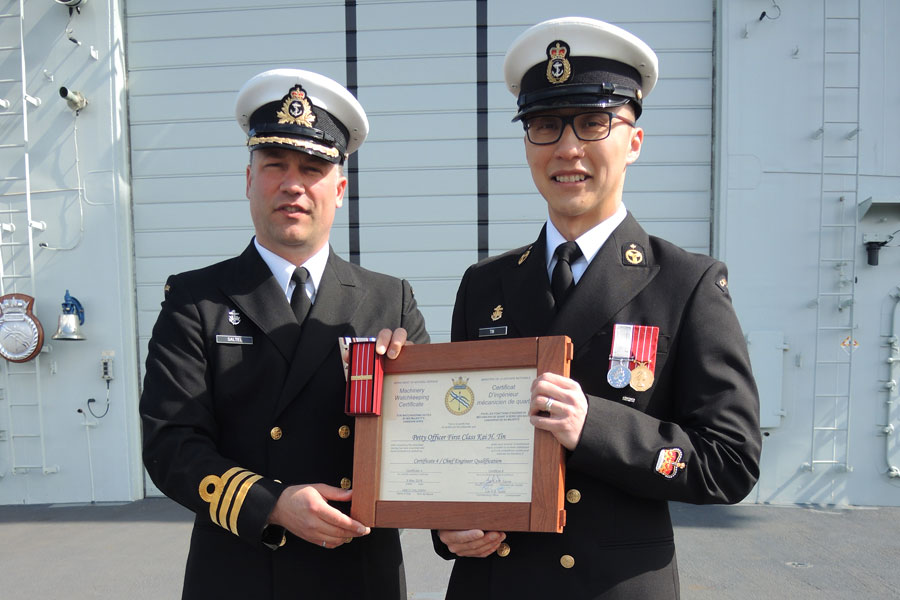Commander Blair Saltel, HMCS Calgary Commanding Officer, presents Petty Officer First Class Kai Tin with his Chief Engineering Level 4 certificate. Photo by Peter Mallett, Lookout