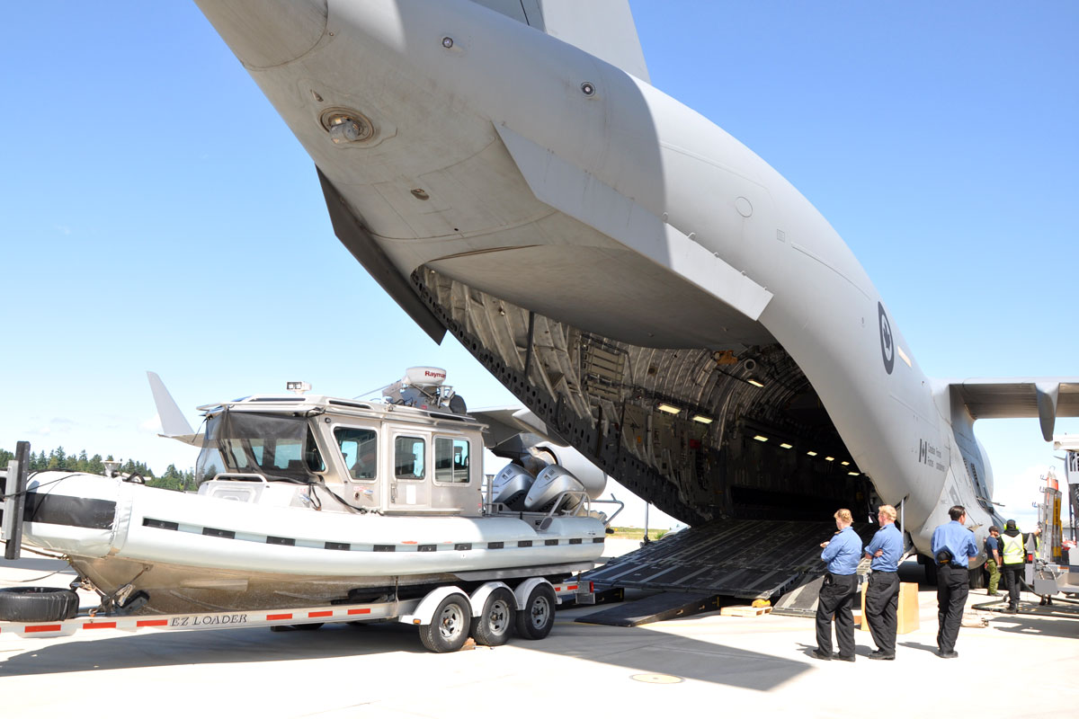 LS Sarah Trull, LS Jason Rupke, and LS Dan Bussel, members of the Naval Security team,  supervise the loading of their equipment into a C17 Globemaster.The plane transported the equipment and members to Fiji for their Force Protection role in Operation Projection. Photo by Lt(N) Melissa Kia