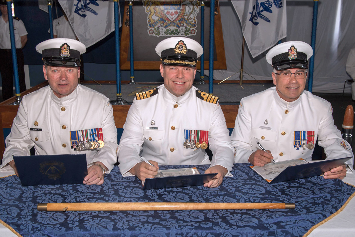 Change of Appointment for Base Chief, from the left: CPO1 Gino Spinelli, outgoing Base Chief; Capt(N) Jason Boyd, Base Commander, and CPO1 Ian Kelly, incoming Base Chief, sign the certificates officiating the transfer of appointment. Photo by LS Mike Goluboff, MARPAC Imaging Services