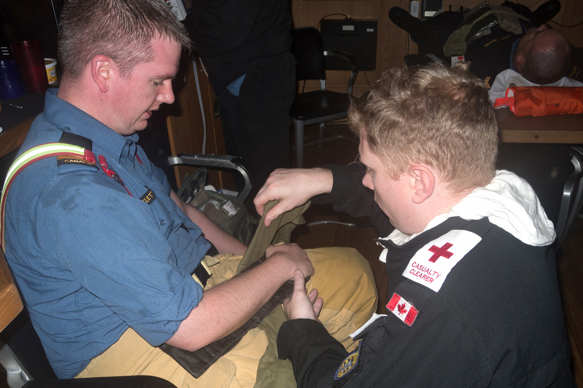 A cook in HMCS Nanaimo works to splint the arm of a crew member with a mock injury. Casualty clearing is a secondary responsibility for the cooks. Photo by Capt Jennifer Jackson