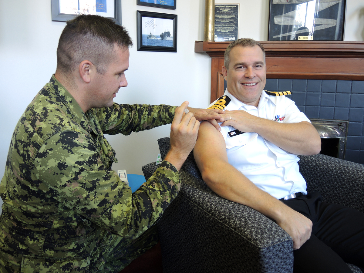 Lieutenant Brian Plinke of Canadian Forces Health Services (Pacific) gives a Flu shot to Base Commander, Captain (Navy) Jason Boyd in his office at Naden. This year’s vaccine was made available to military members on Oct. 1. Flu shots are not mandatory but highly encouraged for all members of the military. For further information about three upcoming clinics on Oct 15, 22, and 29 or about drop-in appointments at the base immunization clinic follow CFB Esquimalt’s base intranet splash pages or call 250-363-4140. Photo by Peter Mallett, Lookout