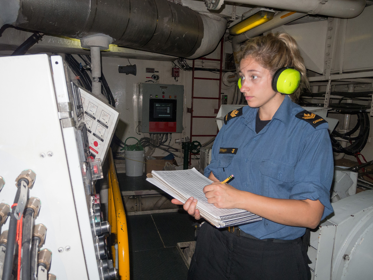 A Marine Technician records information from one of the ship’s diesel alternators as part of rounds.