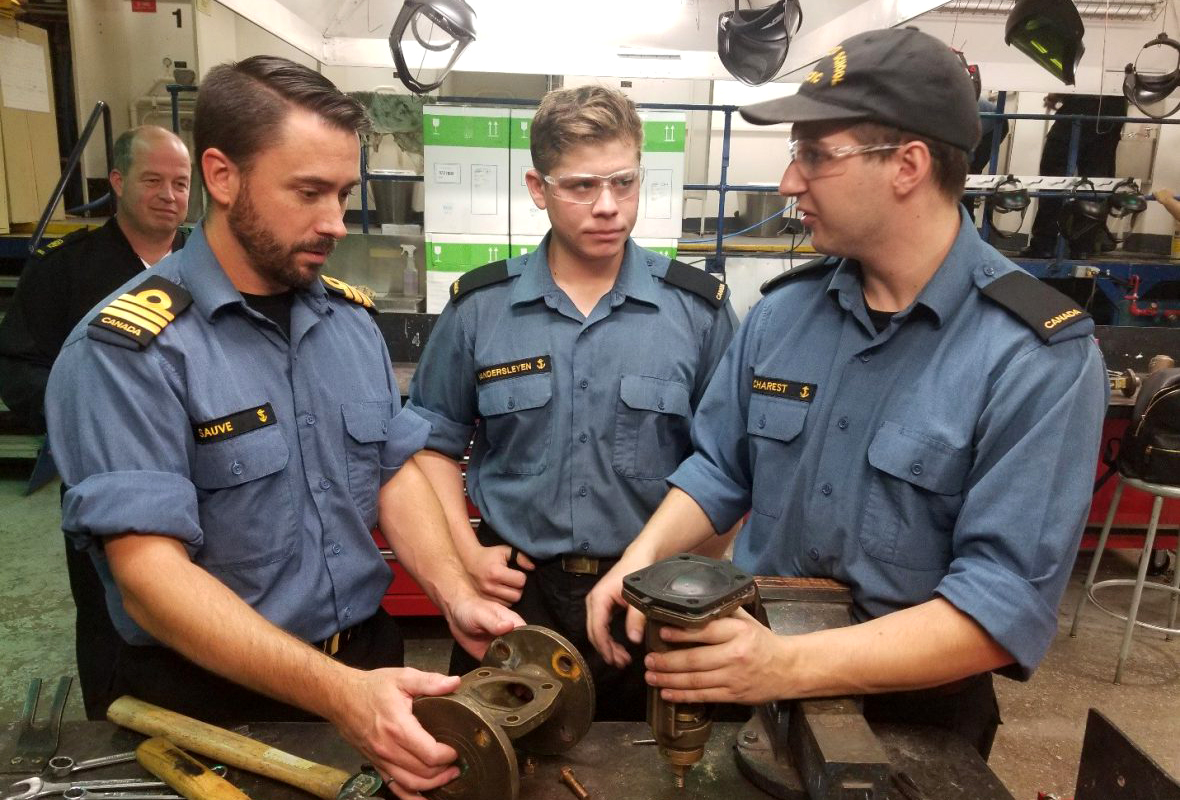 OS Vandersleyen (centre) and OS Charest (right) are joined by Cdr Sauvé, Commanding Officer of the Naval Training Development Center (Pacific), shown here investigating a defective diaphragm valve.