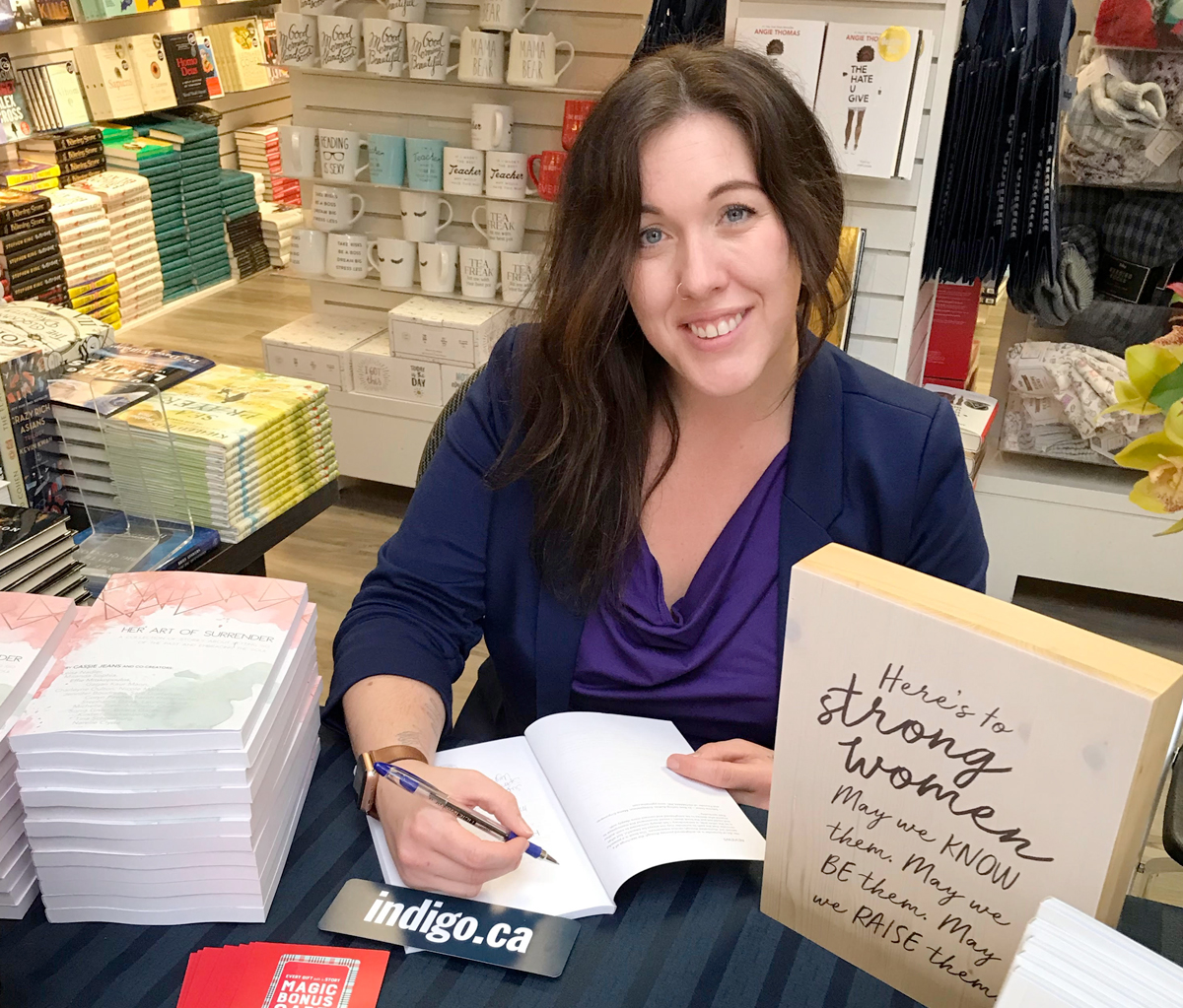 Naval Reservist Ordinary Seaman Charleyne Oulton signs a copy of On Her Plate, a recently released collection of short stories by Golden Brick Road Publishing that contains one of her short stories. Photo by Peter Mallett, Lookout 