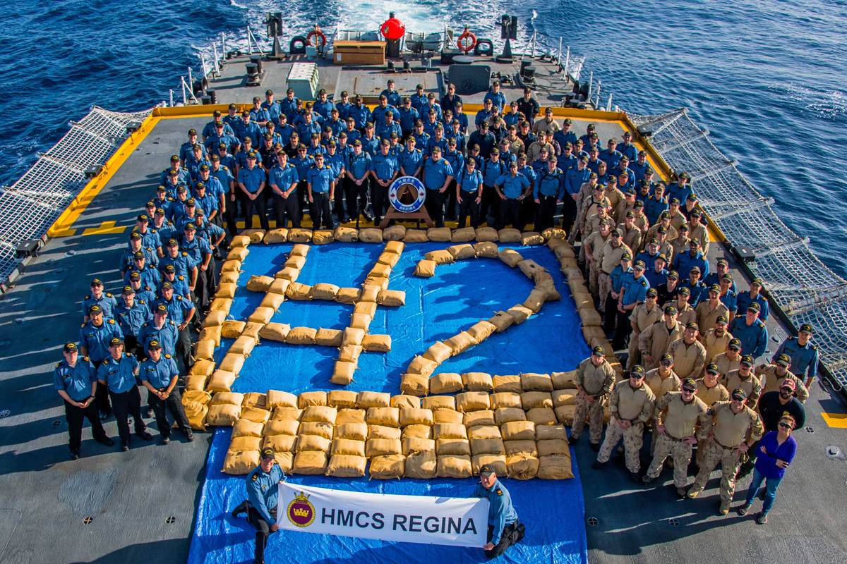 HMCS Regina’s crew poses with over 3,000 kilograms of narcotics seized from a dhow on April 15 during Operation Artemis in the Pacific Ocean. Photo by Corporal Stuart Evans, Borden Imaging Services