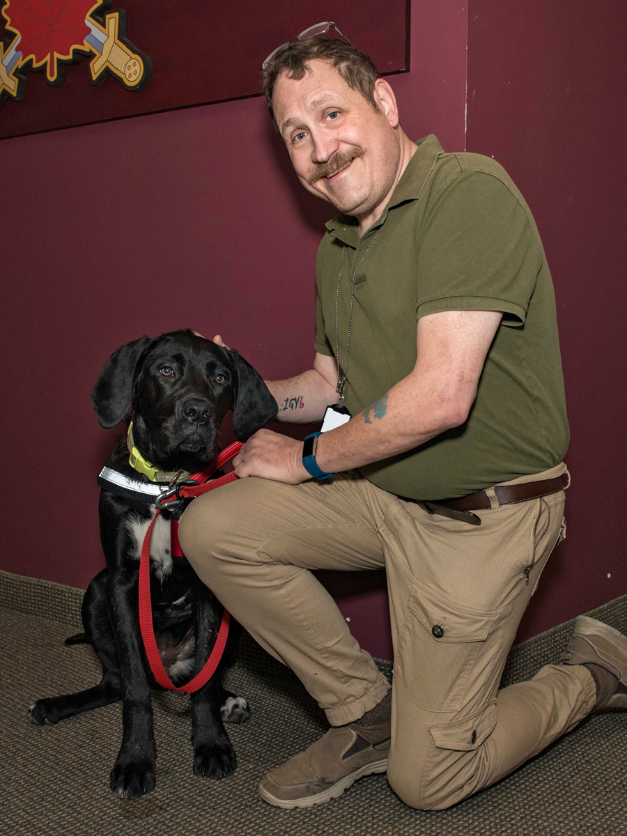 Stephen Holton, Deputy Information Systems Security Officer for the Canadian Army, with his service dog Missie at Canadian Army Headquarters. Photo by Jay Rankin, Directorate of Army Public Affairs