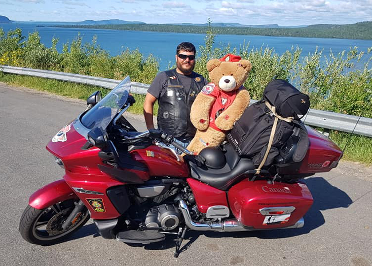 Cpl Alex Millham of CFB Comox poses with Military Police National Motorcycle Relay mascot and social media sensation Ordinary Cadet Moira Stone during this year’s ride.