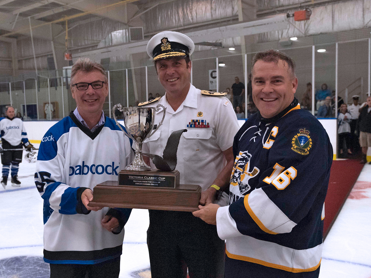 Capt(N) Jason Boyd accepts the Victoria-Class trophy from Commodore Angus Topshee and Babcock Canada’s President Mike Whalley. Photo by LS Bryan Underwood, MARPAC Imaging Services