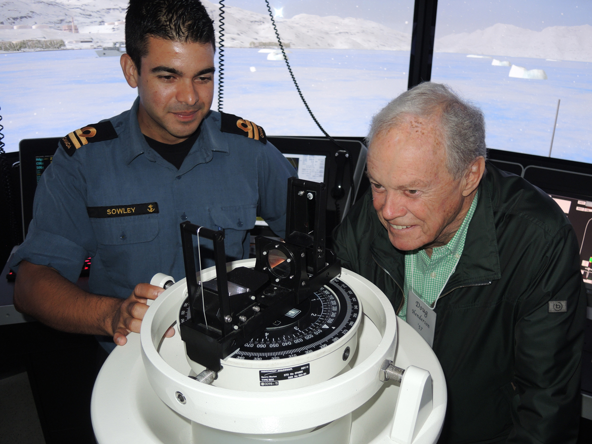 Lt(N) Justin Sowley explains the integration of the pelorus, a reference tool for maintaining bearing of a vessel at sea, with the Naval Bridge Simulator to Cdr (Retired) Doug Henderson. Photo by Peter Mallett, Lookout