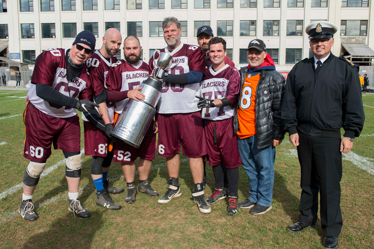 Members of the Fleet Club Slackers celebrate their 20-14 Mini Grey Cup victory along with RAdm Craig Baines, second from right, and Formation Chief CPO1 Derek Kitching. Photo by Avr Renzo Ruiz Hass