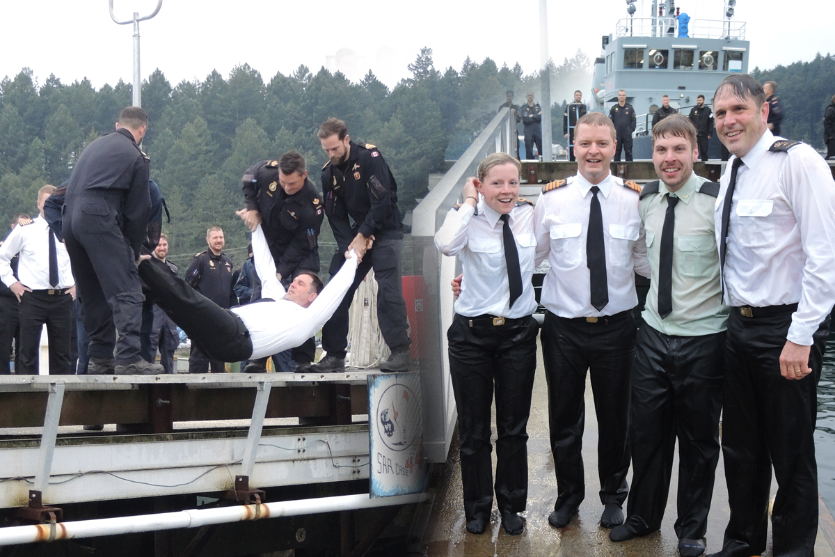 Members of Fleet Diving Unit (Pacific) throw Commodore Angus Topshee into Esquimalt Harbour from ‘G’ Jetty in Colwood on Dec. 11. The event was part of a fundraiser for the National Defence Workplace Charitable Campaign. Photos by Peter Mallett, Lookout