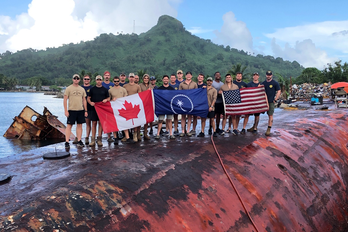 Members of the Fleet Diving Unit (Pacific) and the United States Navy salvage project gather for a team photo on the hull of the MV Micro Dawn in Weno, Chuuk State Federated States of Micronesia. Photo by Lt Byers, MDSU Company 1-3 OIC