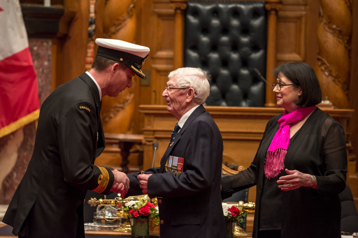 MS (Retired) John Wood shakes hands with Capt(N) Julian Elbourne after receiving a Special Service Medal and Canadian Peacekeeping Service Medal from Lieutenant Governor of B.C. Janet Austin. Photo by Stephanie Raymond