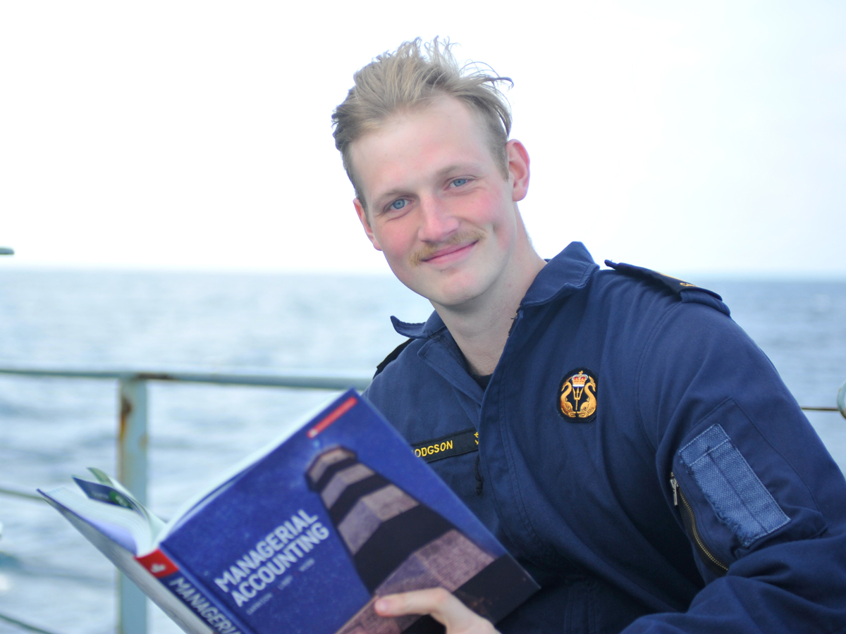 LS Evan Hodgson, a Naval Communicator in HMCS Nanaimo, studies Managerial Accounting while at sea. Photo by Capt Lisa Evong, HMCS Nanaimo Public Affairs Officer