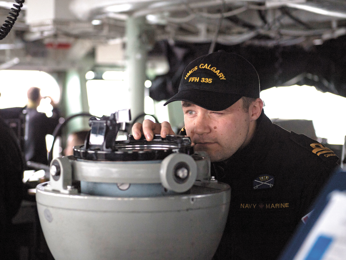 SLt Jason Wychopen takes a bearing from the bridge of HMCS Calgary during Directed Ship Readiness Training.