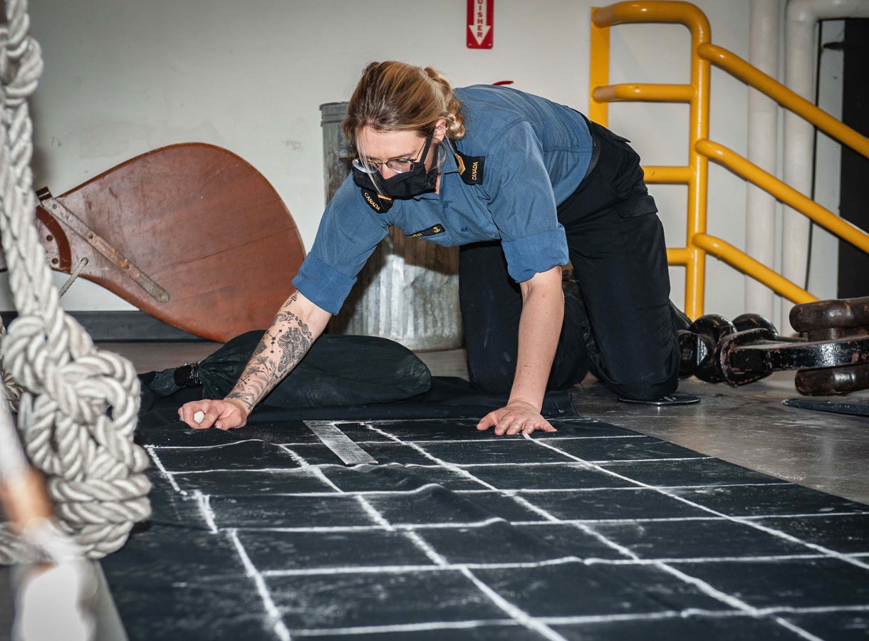 Leading Seaman Brittany Oliver traces patterns to be used in the creation of non-medical face coverings for Canadian Armed Forces members to wear in the wake of COVID-19. Photo by MCpl Carbe Orellana, MARPAC Imaging Services
