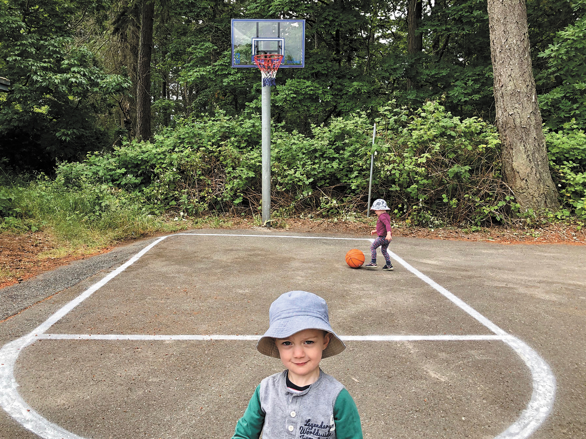 Three-year-old Oliver Forbes (foreground) and his sister, two-year-old Abigail Forbes get ready for some roundball action on the newly refurbished basketball court. Photo Credit Lt(N) Melanie Weaver