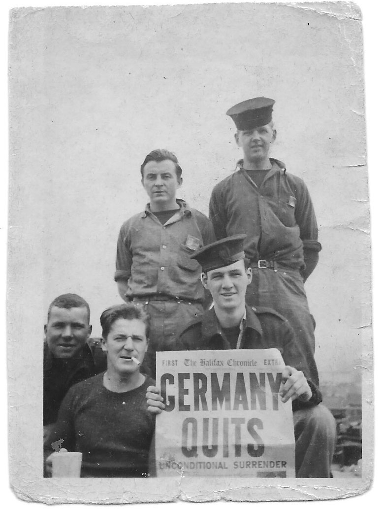 Bill Wilson holds a copy of a local newspaper that reads “Germany Quits”, marking the end of the Second World War.
