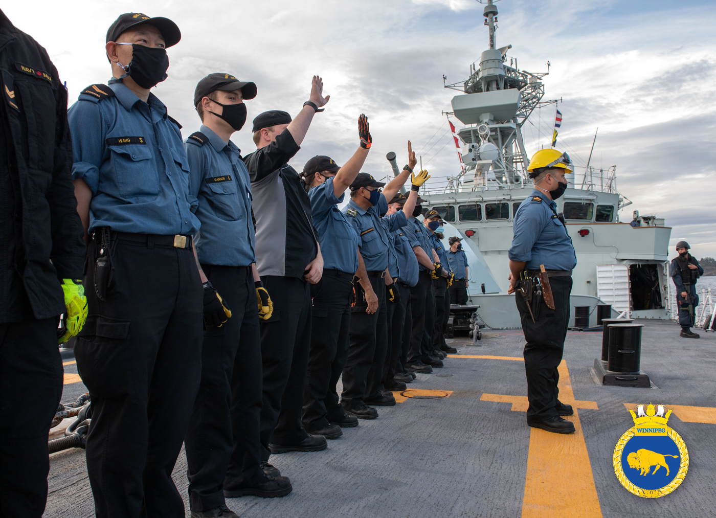Members of HMCS Winnipeg wave goodbye as the ship departs Esquimalt Harbour Aug. 1. For the first several days at sea, sailors wore non-medical masks as a precautionary measure against COVID-19. Due to the global pandemic, Winnipeg sailors will not be exploring foreign ports during their deployment on RIMPAC and Operation Projection/Neon, which will see the ship return in December 2020. Photo by Leading Seaman Valerie LeClair, MARPAC Imaging Services