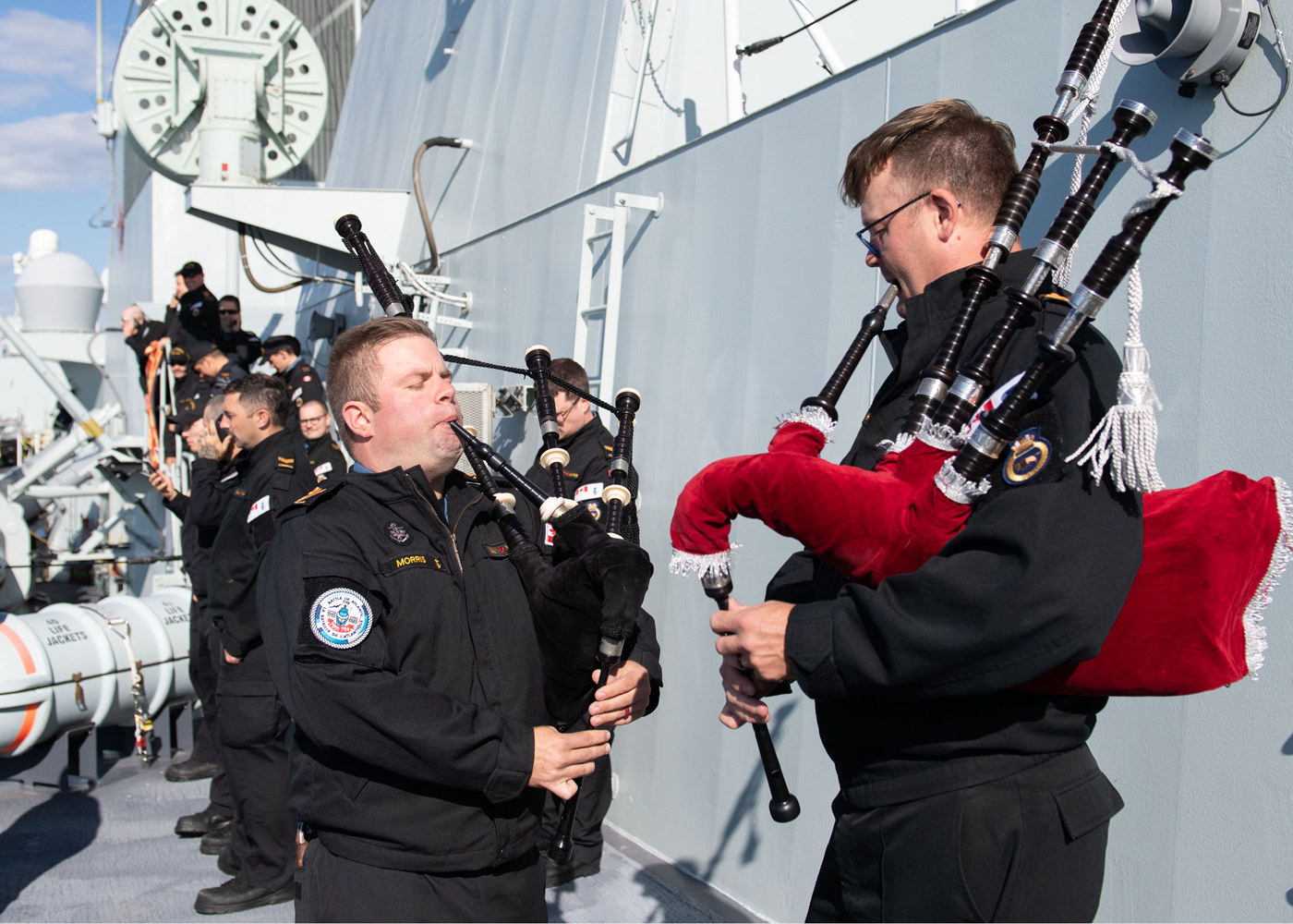 PO2 Robert Morris and SLt Phil Hopkins play the bagpipes during the ship’s departure sail past on Aug. 6.