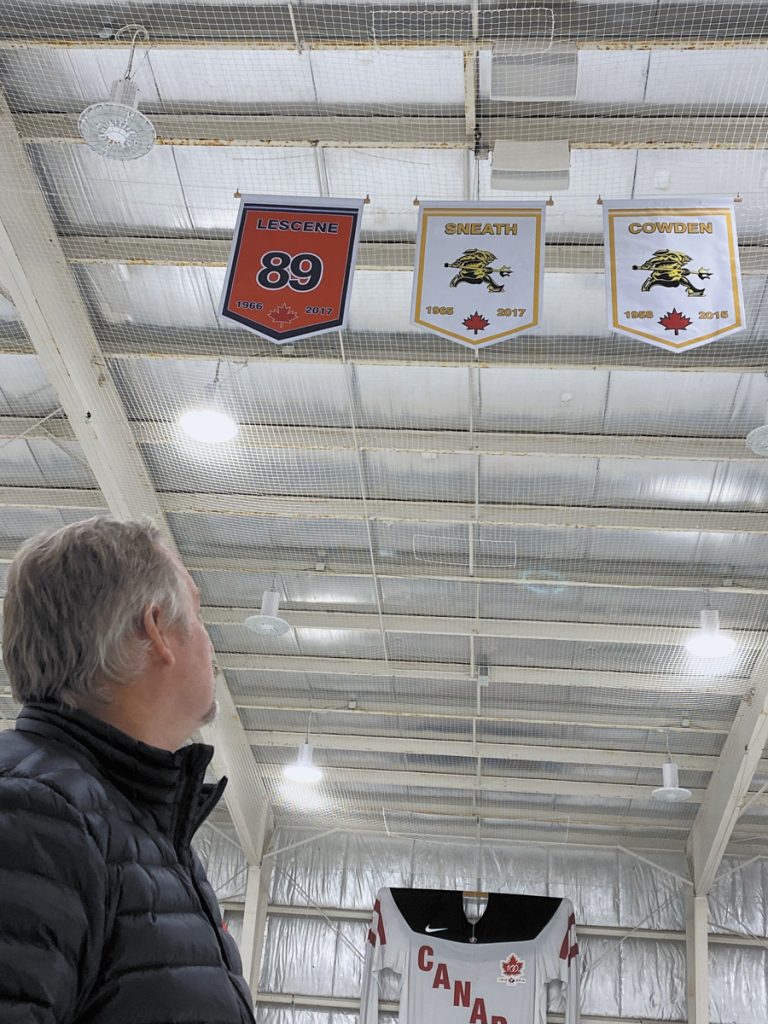 Wurtele Arena Manager Kevin Zalba admires three new banners raised in memory of base hockey players Joe Lescene, Rob Sneath, and Keith Cowden. Photo by Rodney Venis, Base Public Affairs