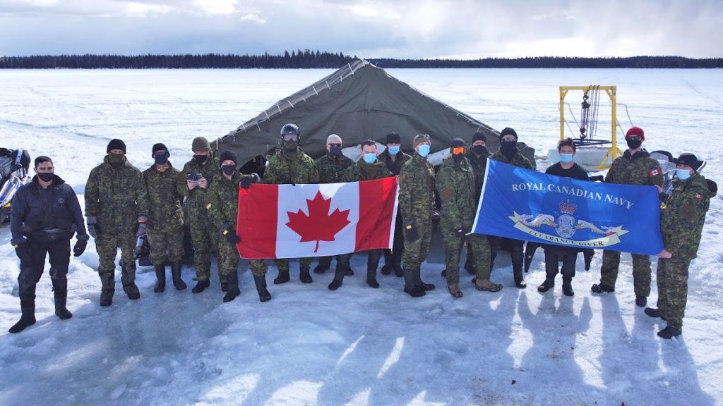 Members of the ICEDIVEX 21 team pose for a group photograph at their dive site out on the lake. Photo by FDU(P)