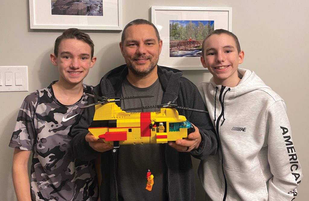 Master Warrant Officer (Retired) Dan Pasieka, centre, holds the LEGO model built by his sons, Mike and Denis, of the CH-113 Labrador he flew in for years as a Royal Canadian Air Force search and rescue technician. The boys are hoping fan support in the LEGO Ideas online group might see their home-build someday fly off store shelves.