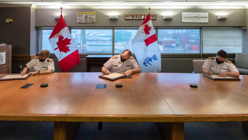 From left: Cdr Michelle Tessier, Cmdre Richard Feltham, and Cdr Nicole Robichaud sign documents marking the Change of Command for the future HMCS Margaret Brooke on April 30. Photo: CFB Halifax Formation Imaging Services