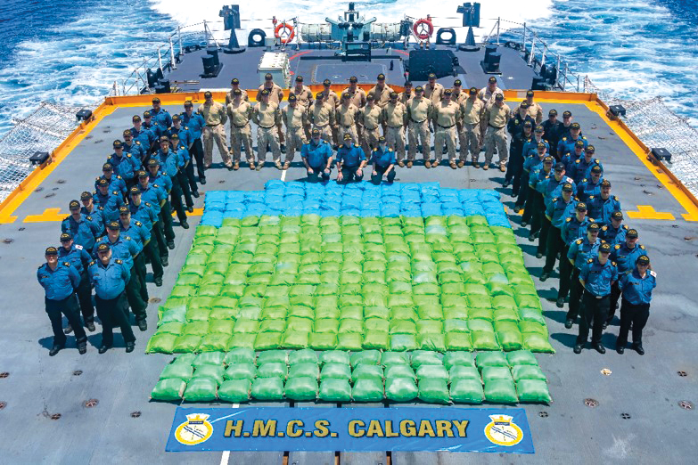 Members of HMCS Calgary stand with 3,350 kilograms of hash seized from a dhow during a counter-smuggling operation on April 30 in the Arabian Sea, as part of Operation Artemis with  Combined Task Force 150.  Photos by Cpl Lynette Ai Dang, HMC Calgary Imagery Technician