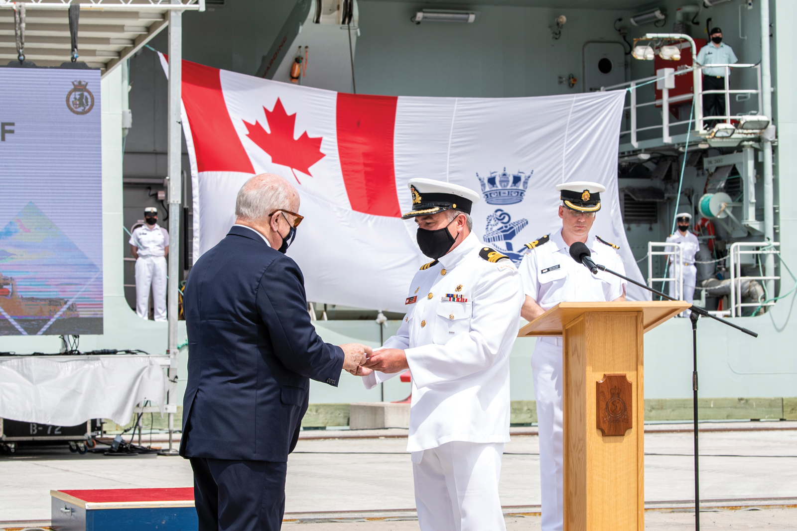 The Honourable Arthur J. LeBlanc, Lieutenant Governor of Nova Scotia, presents Commander Corey Gleason, Commanding Officer HMCS Harry DeWolf, with the Commissioning Pennant. 