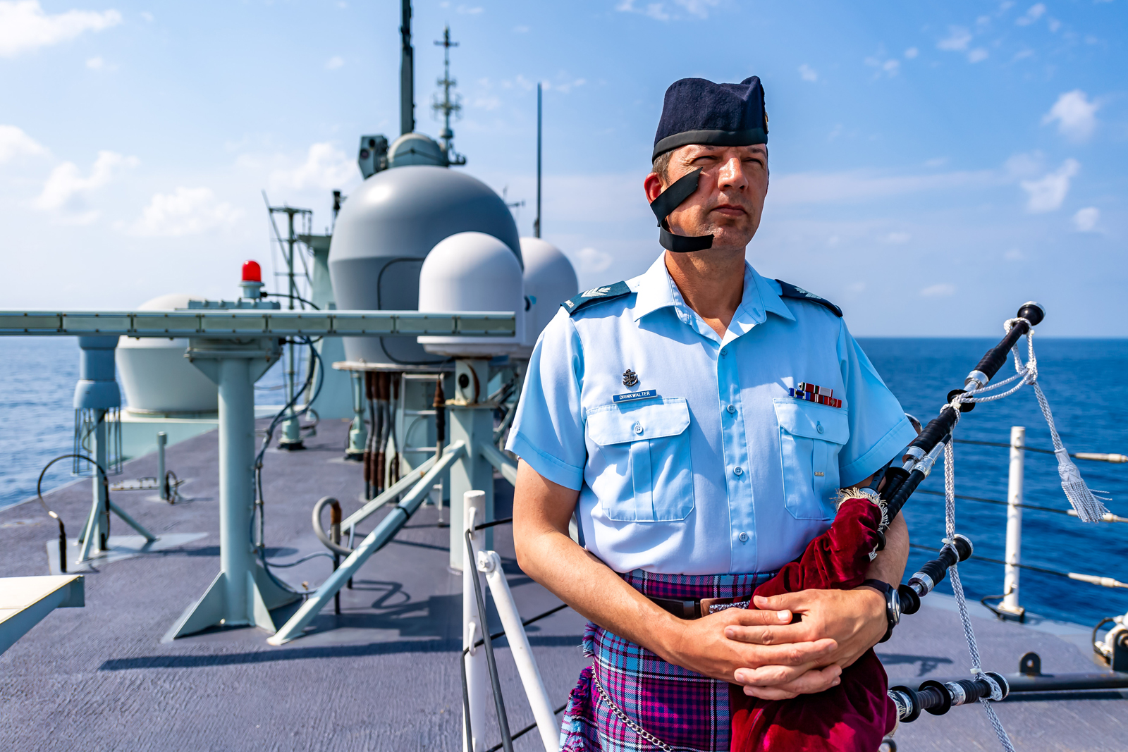 Sergeant Steven Drinkwalter played the bag pipes during the Battle of the Atlantic ceremony on May 2 in the Arabian Sea while the ship was on Operation Artemis and part of Combined Task Force 150. Photo by Cpl Lynette Ai Dang, HMCS Calgary Imagery Technician