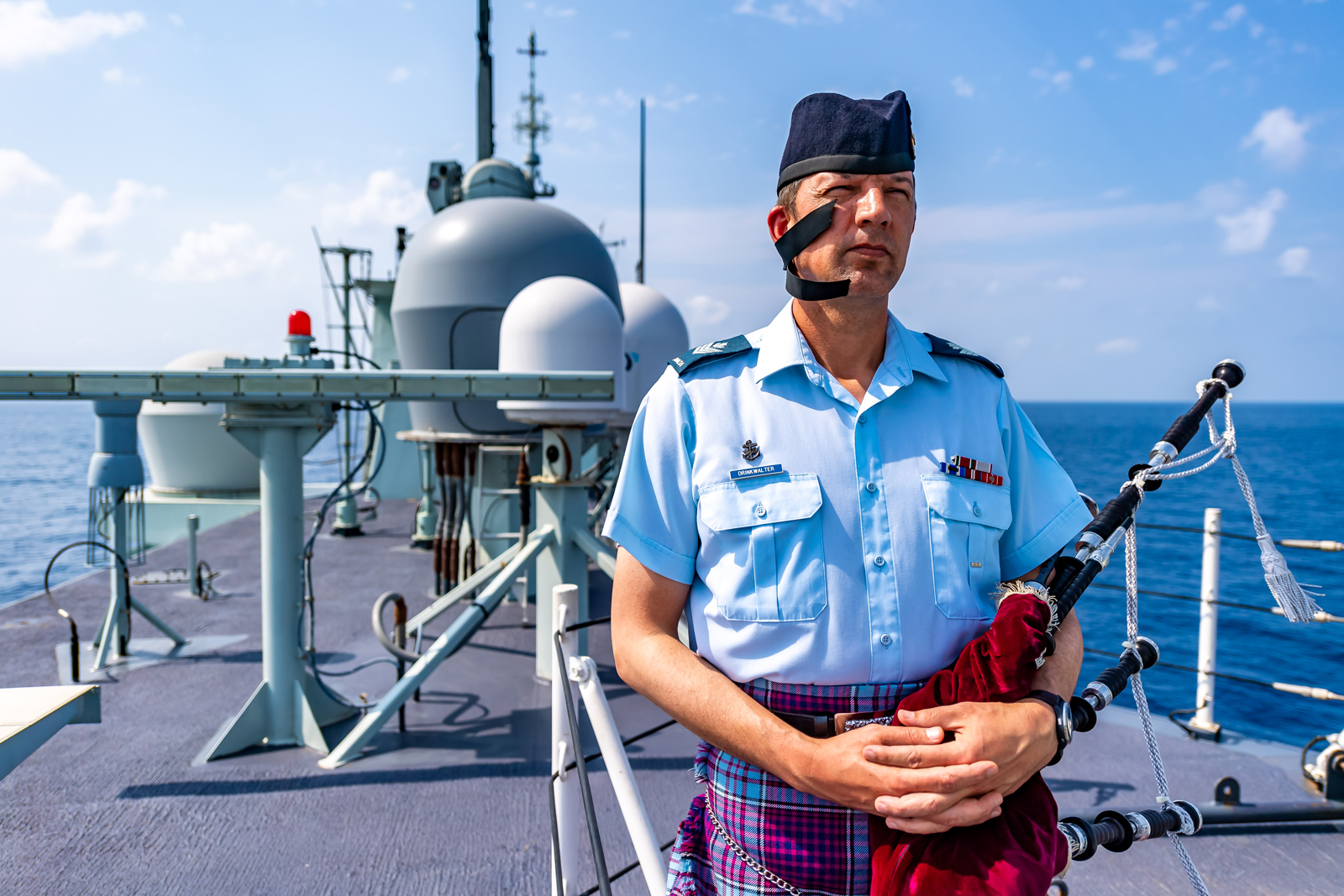 Sergeant Steven Drinkwalter played the bag pipes during the Battle of the Atlantic ceremony on May 2 in the Arabian Sea while the ship was on Operation Artemis and part of Combined Task Force 150. Photo by Cpl Lynette Ai Dang, HMCS Calgary Imagery Technician