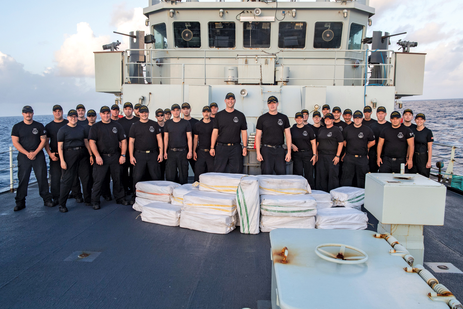 The ship’s company of HMCS Shawinigan is seen with illegal drug contraband seized during Operation Caribbe in the Caribbean Sea on July 21. CAF Photo