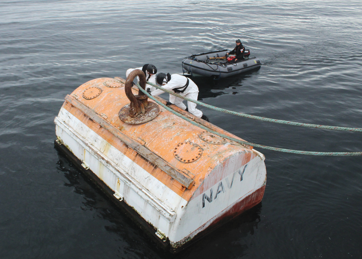 Buoy jumpers attach a hawser to a mooring buoy. Photo by SLt Wilson Ho