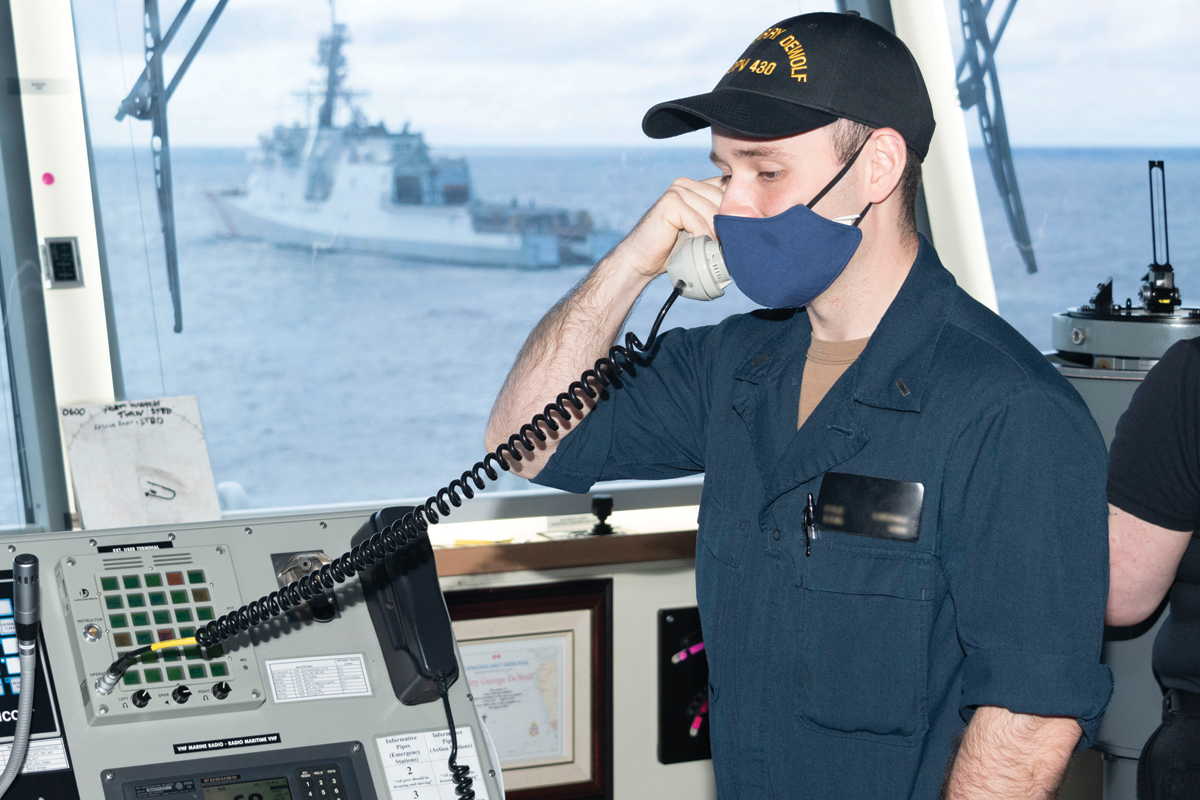Lieutenant Junior Grade Kyle Luchau, a United States Navy sailor on exchange with HMCS Harry DeWolf, at work on the ship’s bridge.