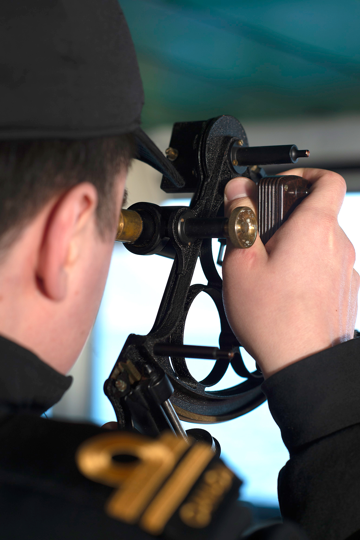 SLt Nick Zanko trys out a sextant on the bridge of HMCS Brandon. 