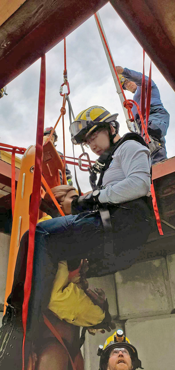 A USAR member is hoisted down during a vertical lift exercise while other members of the USAR Team observe.  Photo: Sub-Lieutenant Wilson Ho – USAR Team Member