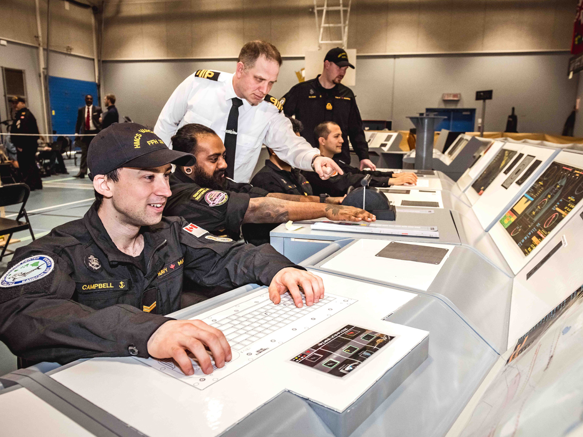 Under the supervision of Lieutenant-Commander (LCdr) David Canning, CSC Project Director (DNMCP), MARPAC sailors familiarize themselves with the layout of the proposed Canadian Surface Combatant (CSC) bridge design. Left to right: Sailor First Class (S1) Nicholas Campbell, S1 Isaac Priyanthan, (Obscured), Sailor Second Class Daniel Yaretz, and Lieutenant (Navy) Aidan De Boer.