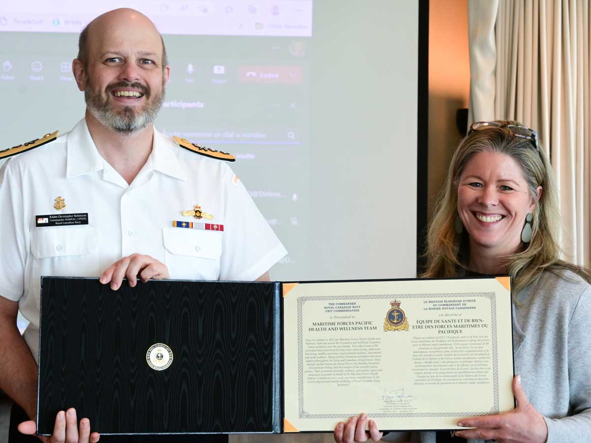 Rear-Admiral Christopher Robinson, Commander MARPAC/JTF(P), presents the Commander Royal Canadian Navy Unit Commendation to Maryse Neilson, Health Promotion Manager and member of the MARPAC Health and Wellness Strategy.