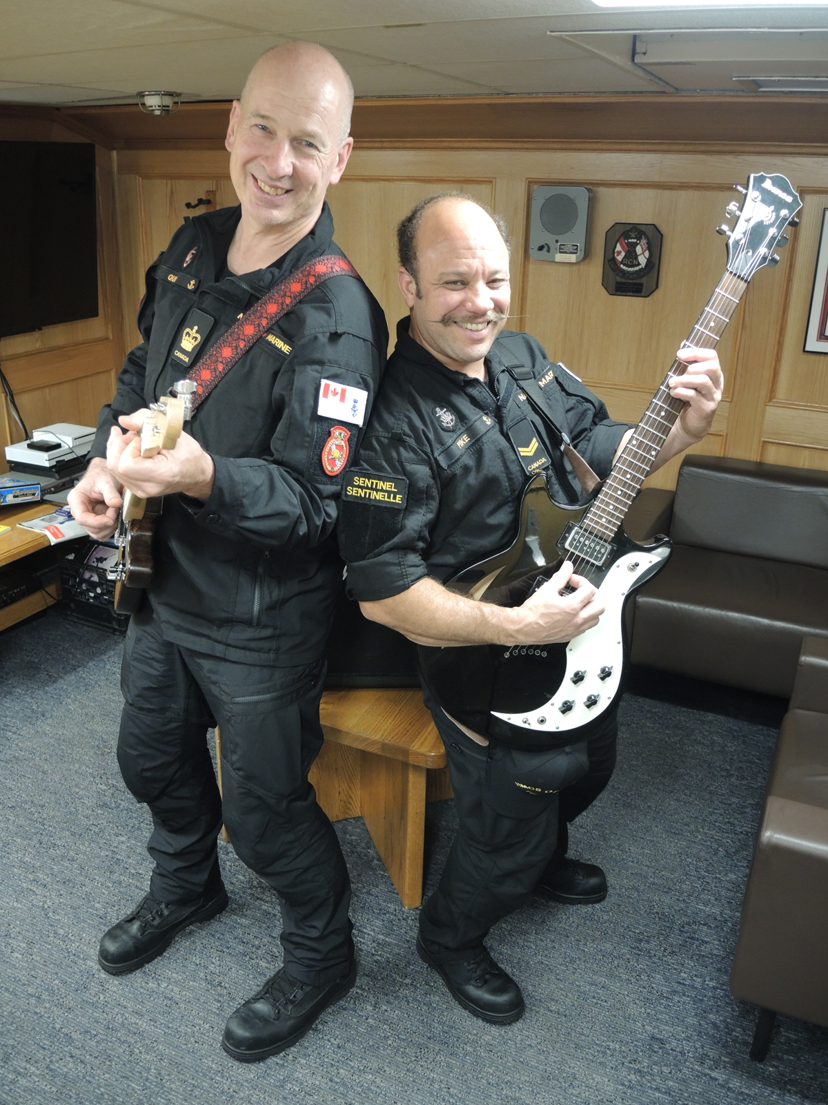 Petty Officer First Class Paul Quin and Sailor First Class Syl Pike practise playing their guitars in the Chief and Petty Officers' Mess aboard HMCS Ottawa. The two sailors have launched a program to provide musical instruments to sailors aboard ship during its upcoming deployment to the Indo-Pacific region. Photo: Peter Mallett/Lookout Newspaper.  
